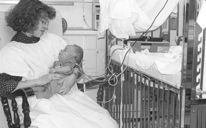 Susan Niermeyer, MD, rocking a baby in the Newborn Center