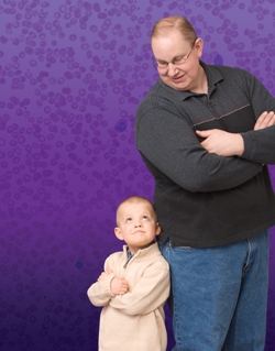 Kevin and Ethan, leukemia cancer survivors who were treated at Children's Hospital Colorado, stand back to back in front of a purple wall.