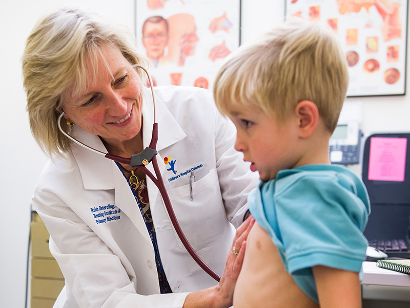 Dr. Robin Deterding, of the Breathing Institute at Children's Hospital Colorado, listens to a kid's lungs with a stethoscope.