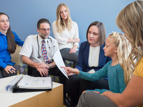 (From left) Pediatric gastroenterologist Edward Hoffenberg, MD; genetic counselor Alexandra Suttman, MS, CGC; and pediatric oncologist Lindsey Hoffman, DO, talk genetics with a patient and her mom.