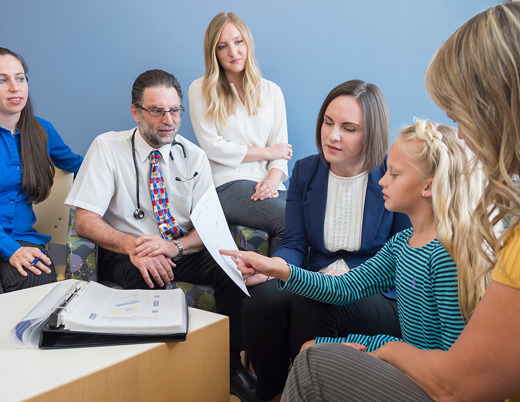 (From left) Pediatric gastroenterologist Edward Hoffenberg, MD; genetic counselor Alexandra Suttman, MS, CGC; and pediatric oncologist Lindsey Hoffman, DO, talk genetics with a patient and her mom.