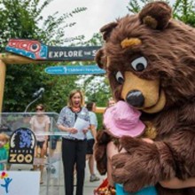 Children's Hospital Colorado's new mascot, Elbert the Bear, hugs a girl at the Denver Zoo.