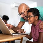 Father and son looking at something on a laptop.