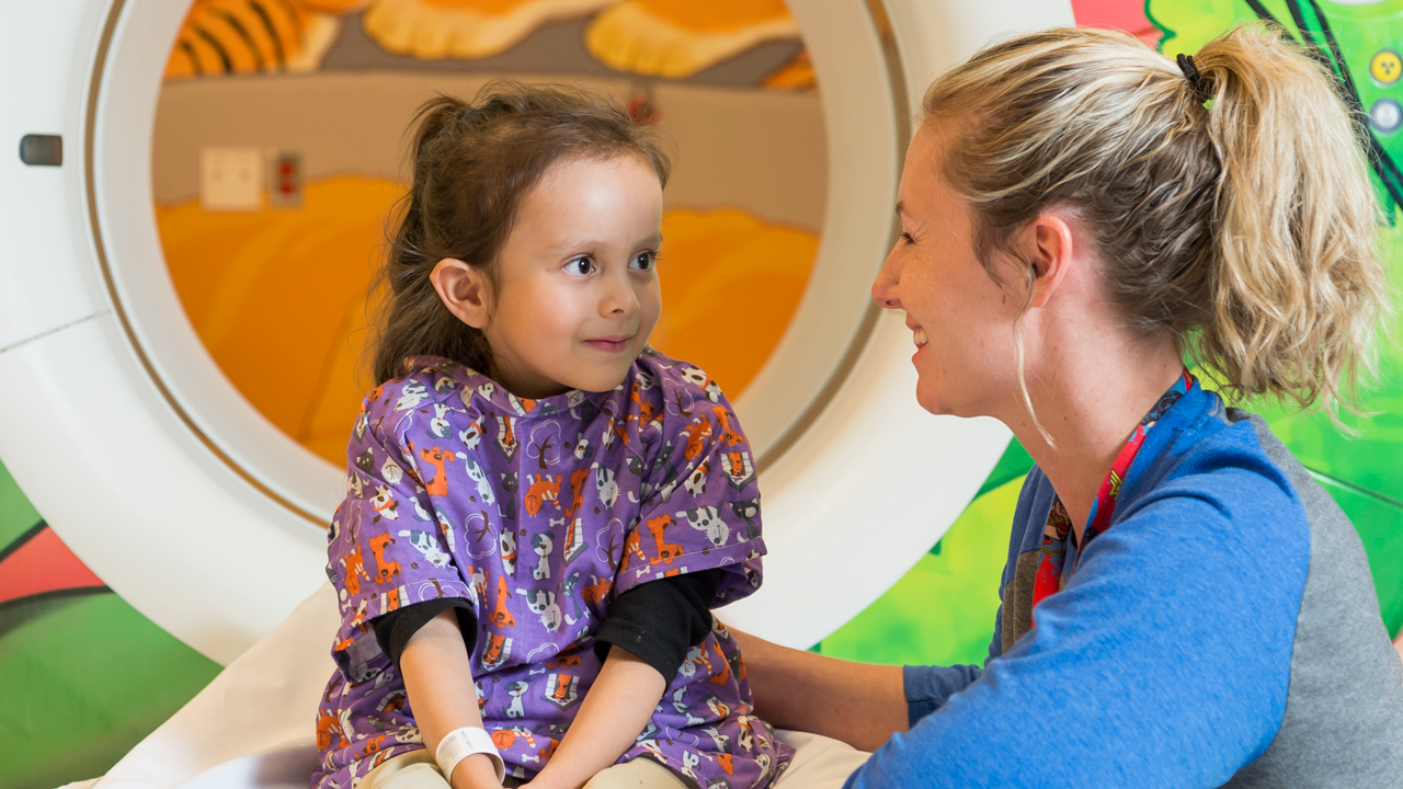 A pediatric radiologist comforts a young girl before a CT scan at Children's Colorado.