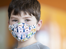 Young boy wearing a mask.