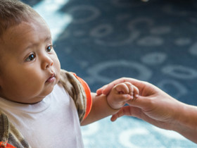 Dr. Sarah Sibbel examines a toddler's hand.
