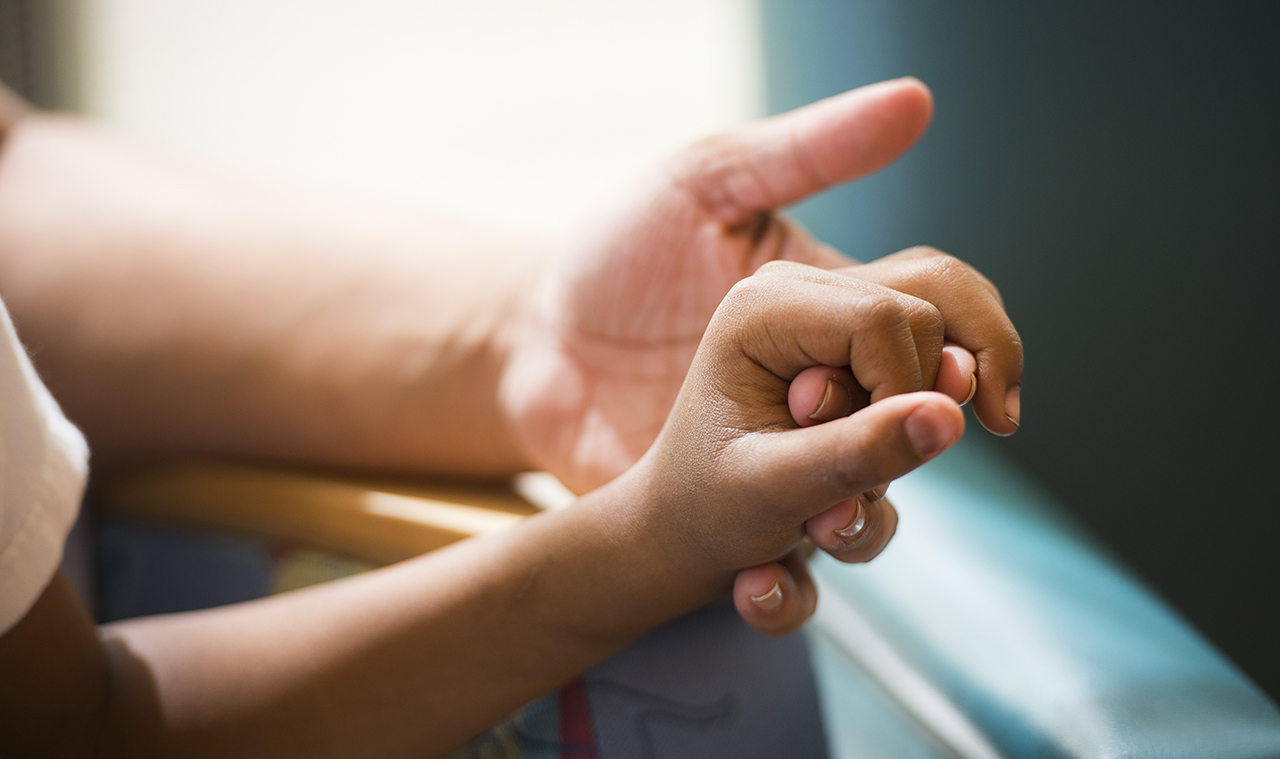 A parent holds a child's hand as part of a research study about age of cancer diagnosis.